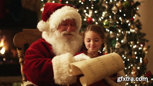 Santa Claus reading a list with a girl on his lap