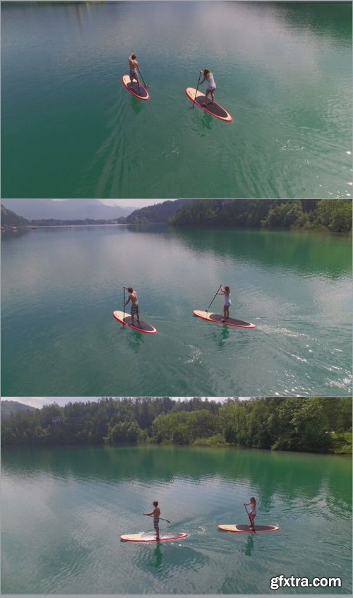 AERIAL Girlfriend And Boyfriend SUP Boarding Towards The Lake Island Bled