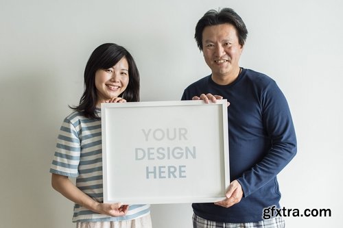 Asian couple holding photo frame together mockup