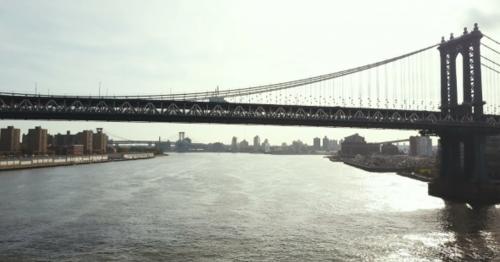 Aerial View of Brooklyn Bridge Through the East River in New York, America. Drone Flying Under the - A5JC8ZU