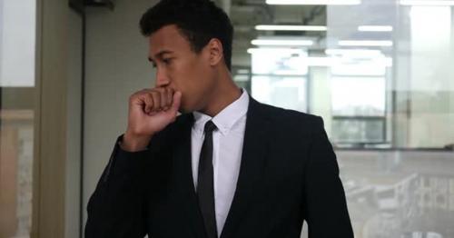 Coughing Young Black Businessman in Office - F3GWQXT