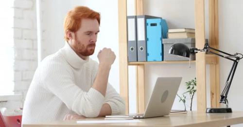 Man with Red Hairs Thinking and Working in His Office - 9FZ6YLJ