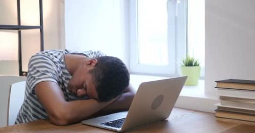 Sleeping Black Man at Work, Head on Desk - 6AFGBZW