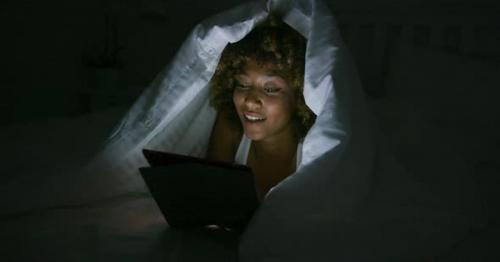 Woman Using Tablet Under Blanket - LFN38GQ