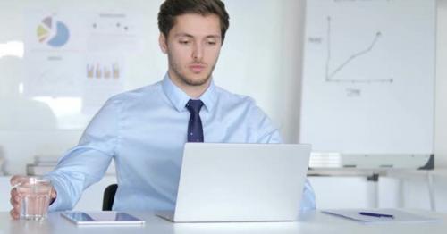 Young Businessman Drinking Water at Work - VKGCP27