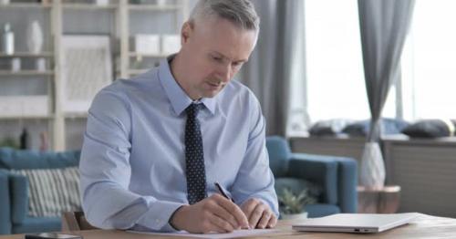 Gray Hair Businessman Writing a Letter - HZFJ75X