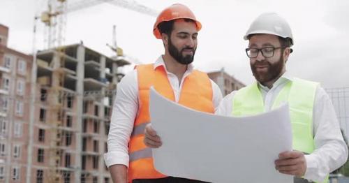 Smiling Male Construction Engineer Discussion with Architect at Construction Site or Building Site - ZL4SAQ6