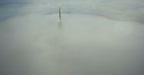 Drone Is Flying Away From Amazing Mont Saint Michel Castle Steeple Statue Above Clouds in the Sky - SACKQFW