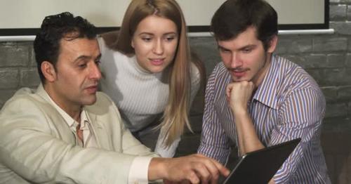 Group of Business People Discussing Something on the Laptop During the Meeting - FZXLAC3