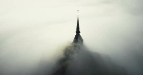 Aerial Shot of Sunrise Fog Clouds Covering Mysterious Heavenly Castle of Mont Saint Michel Fortress - RDQNU23