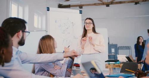 Young Professional Female Law Firm Expert in Glasses Sharing Experience with Multiethnic Office - Y9P7TH6