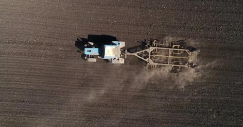 Aerial View of Agricultural Tractor Cultivating Field. Tractor At Work. - HXDBWQN