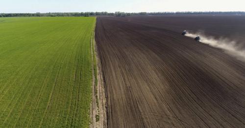 Aerial View of Agricultural Tractors Cultivating Field. - 6R9USEV