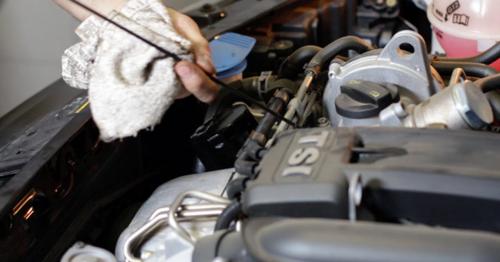 Car Repair Mechanic Checking the Oil Level - V2G6RLJ