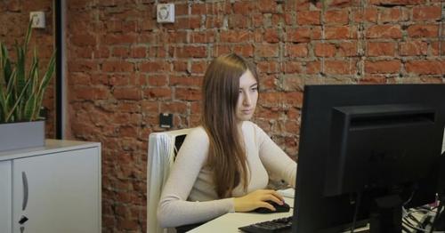 Female Specialist Looking at Computer Screen Sitting in Modern Office. - WUD5VT4