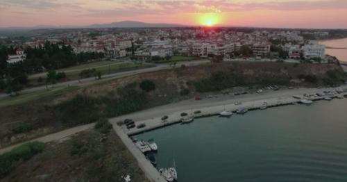 Flying Over the Quay and House Roofs at Sunset. Nea Kallikratia, Greece - V9MPH43