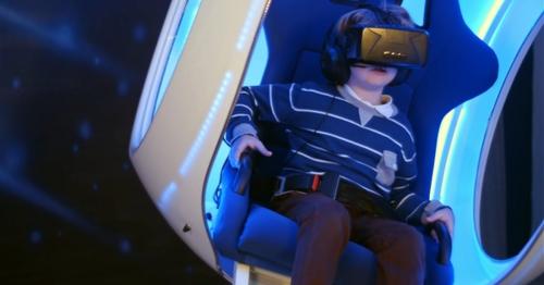 Little Boy Experiencing Virtual Reality Sitting in Interactive Moving Chair - YMSHKZ8