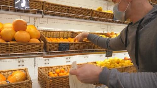 Videohive - Man with Medical Face Mask Selects Mandarins in Store. Guy Choose Fruits in Supermarket. Purchase