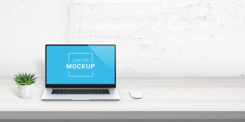 Laptop Mockup On Office Desk With Free Space Beside For Promo Text. Plant And Mouse Beside. White Brick Wall In Background. Scene Creator With Isolated Layers Premium PSD