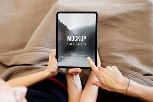 Couple using a tablet screen mockup together in bed - 2206506