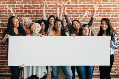 Group of diverse women showing a blank banner mockup - 1223858