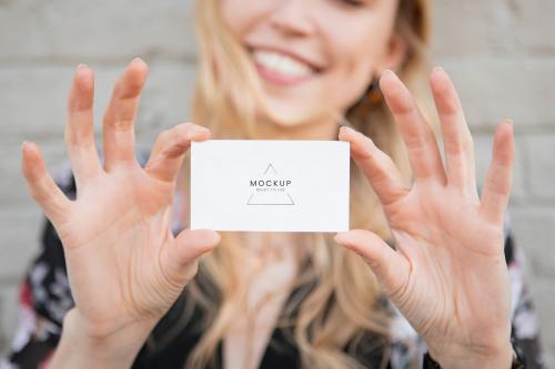 Cheerful white woman showing her business card mockup - 1208442