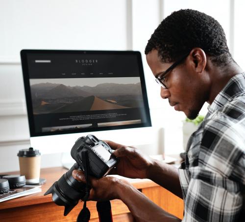 Black photographer sitting by his computer screen mockup - 1209076