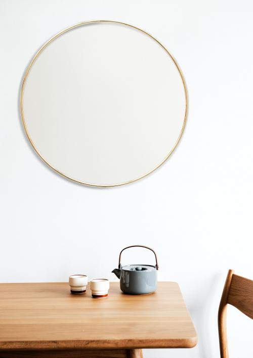 Golden frame on a white wall by a tea set - 1212841