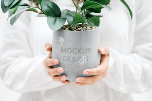 Woman holding a gray plant pot mockup - 1215133