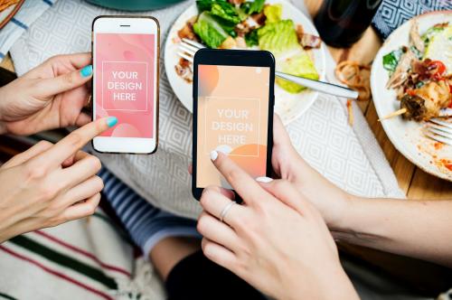 Friends showing mobile phone mockups at a dinner party - 894833