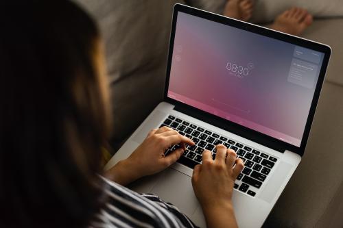 Woman working on a laptop screen mockup on the couch - 894853