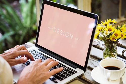 Woman using a laptop screen mockup in a cafe - 894866