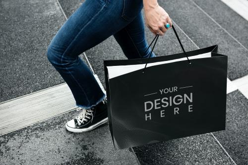 Woman carrying a black shopping bag mockup - 894874