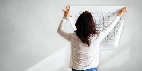 Female architect checking a blueprint - 895146