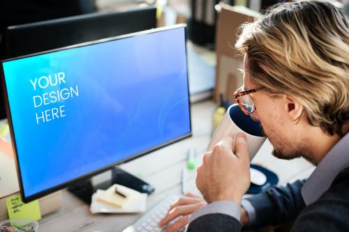 Businessman drinking a coffee whilst using a computer mockup - 598456