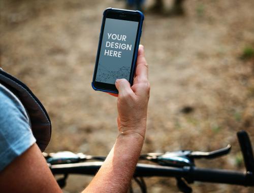 Female cyclist holding a phone mockup - 598461