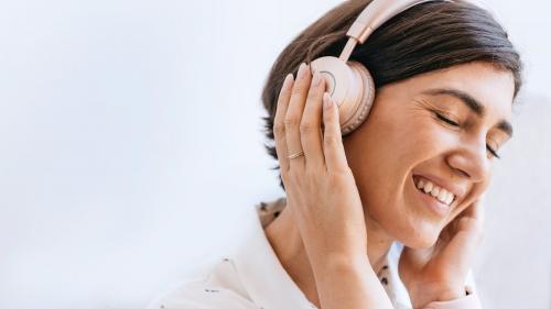 Happy woman with headphones on the couch - 2033304