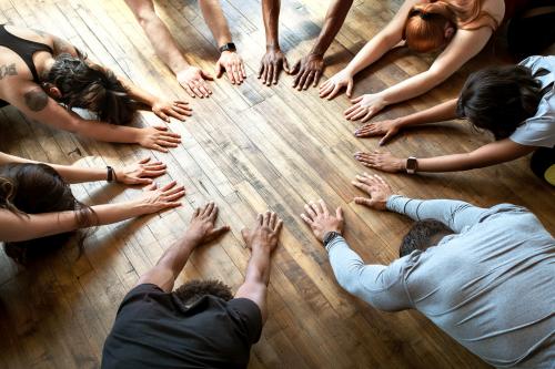 Diverse people doing a Balasana pose in a circle - 2041701