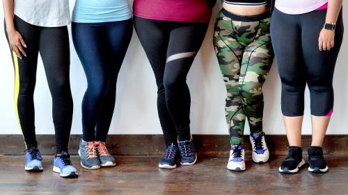 Group of sportive women standing by a brick wall - 2045860