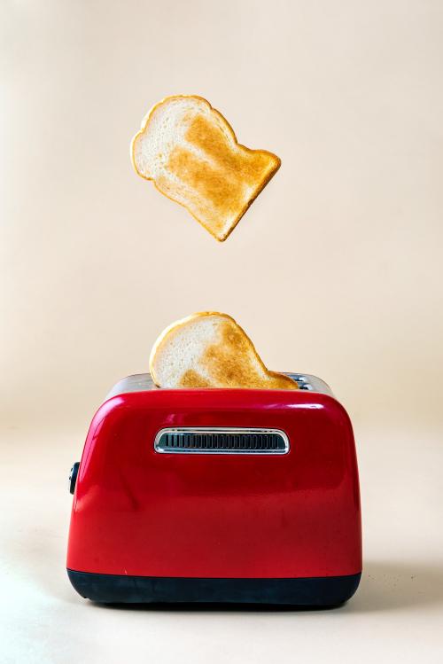 Roasted toast bread popping up from a red toaster - 2051002