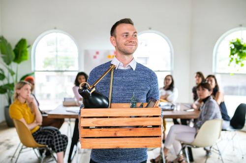 Young businessman leaving office with his personal belongings - 2204204