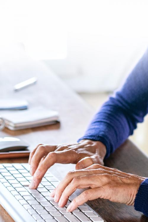 Senior woman typing on a computer keyboard - 2205422