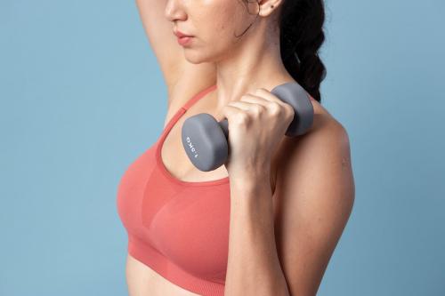 Sporty woman lifting dumbbells on blue background - 2254172