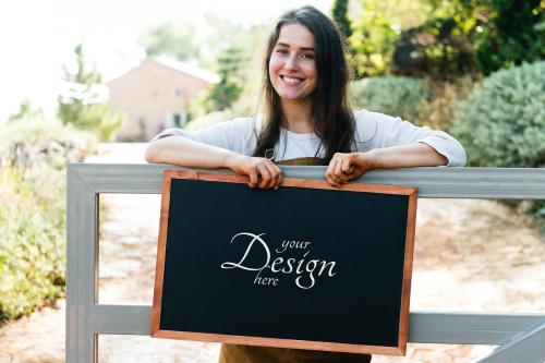 Female farmer holding a blackboard mockup - 844034