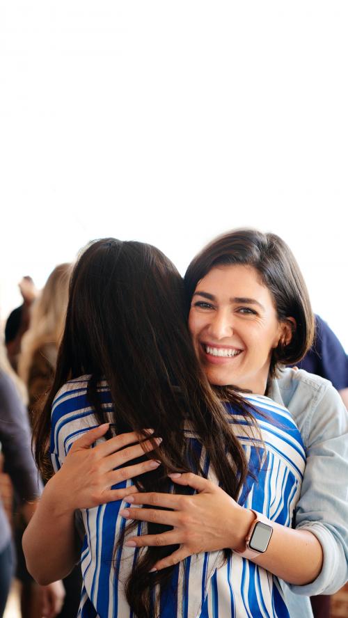 Woman embracing her friend in a workshop - 2027386