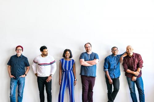 Group of people standing in a by a white wall - 2051198