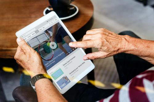 Old man watching the news on a digital tablet - 538979