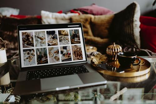 Laptop on a glass table showing a photo feed - 540858