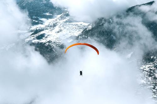 Paragliding on a cloudy day through the mountain - 2255104