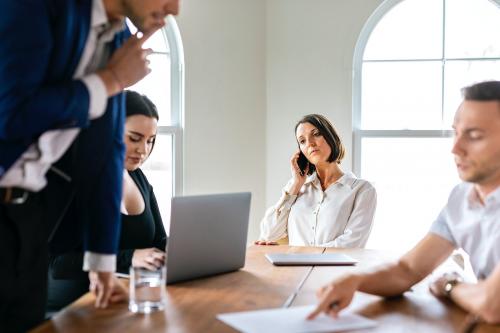 Businesswoman talking on a phone in a meeting - 2203517